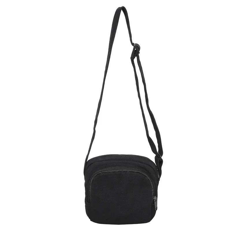 Borsa a tracolla nera in tessuto, design compatto con cerniera, ideale per uomo e donna. Accessorio moda pratico e versatile.