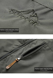 Giacca outdoor verde con logo ricamato, tasca con cerniera sul petto, design pratico e alla moda. Ideale per attività all'aperto.