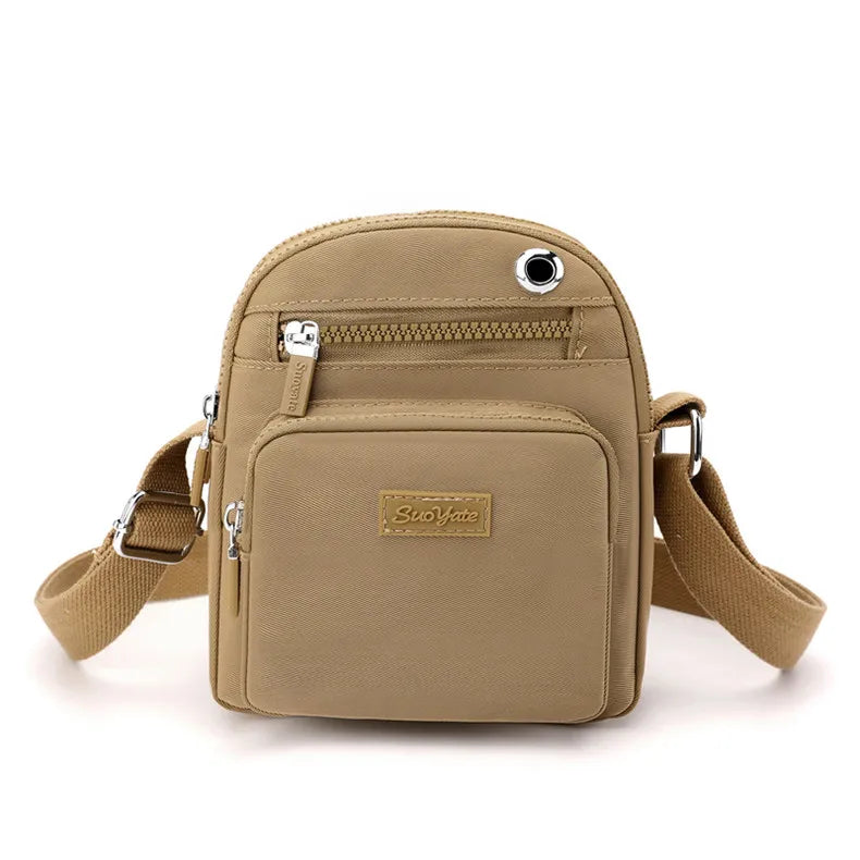 Borsa a tracolla beige in pelle sintetica, con tasche multiple e cerniere, ideale per uomo e donna. Design compatto e moderno.