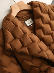 Giacca trapuntata marrone su appendiabiti, design a quadri, tessuto imbottito, ideale per l'inverno. Moda donna, abbigliamento caldo e confortevole.