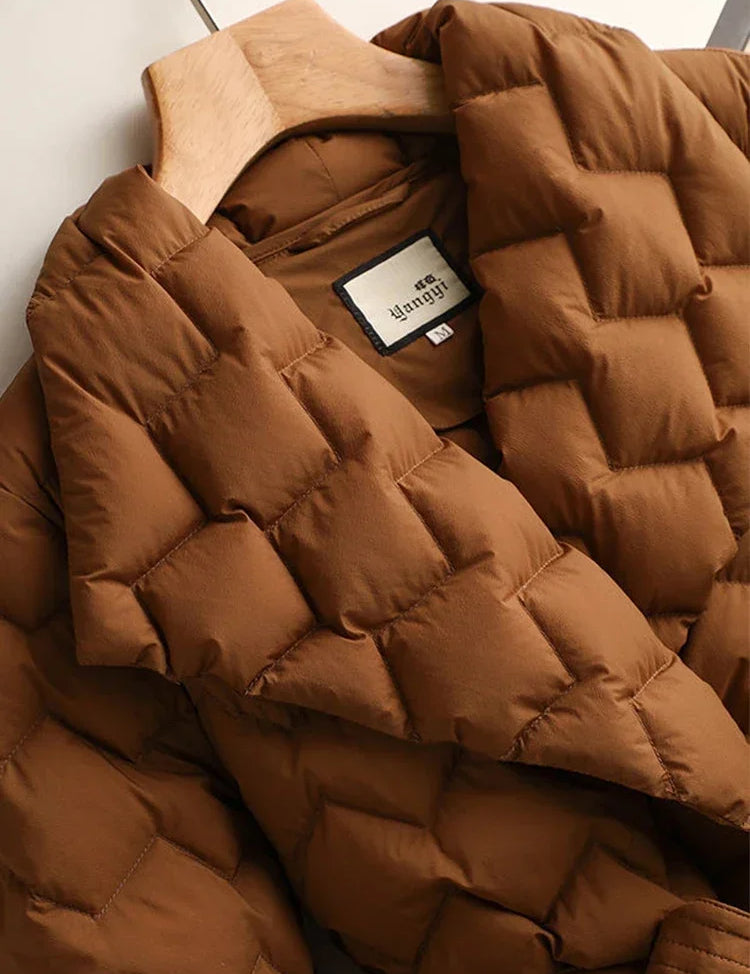 Giacca trapuntata marrone su appendiabiti, design a quadri, tessuto imbottito, ideale per l'inverno. Moda donna, abbigliamento caldo e confortevole.