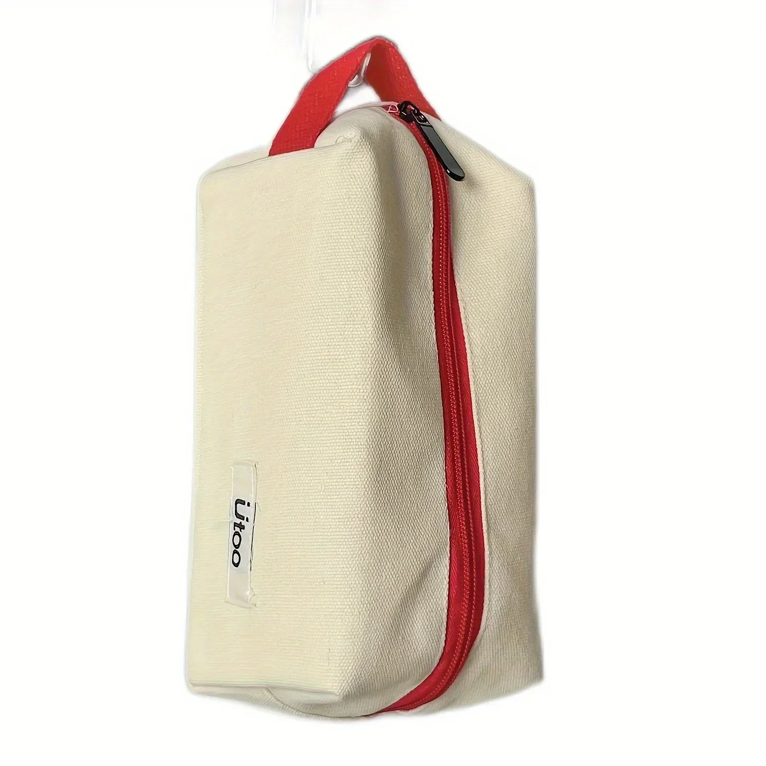Astuccio da viaggio in tela beige con cerniera rossa e manico rosso, ideale per cosmetici e accessori. Design compatto e resistente.