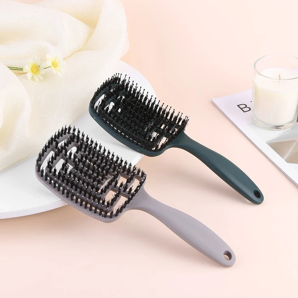Due spazzole per capelli rettangolari su sfondo rosa, una nera e una grigia, con setole morbide. Accessori per la cura dei capelli, eleganti e funzionali.