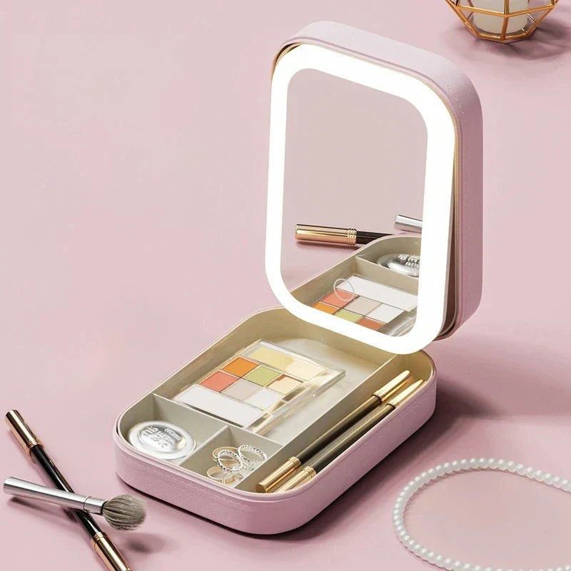 Specchiera portatile rosa con luci LED, scomparti per trucchi, pennelli e gioielli. Design compatto, ideale per viaggi e organizzazione cosmetici.