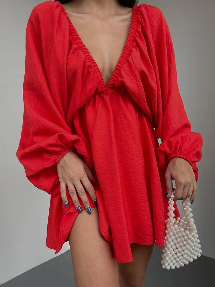 Donna con abito rosso a maniche lunghe e scollatura profonda, borsa di perle. Moda elegante, abbigliamento femminile trendy.