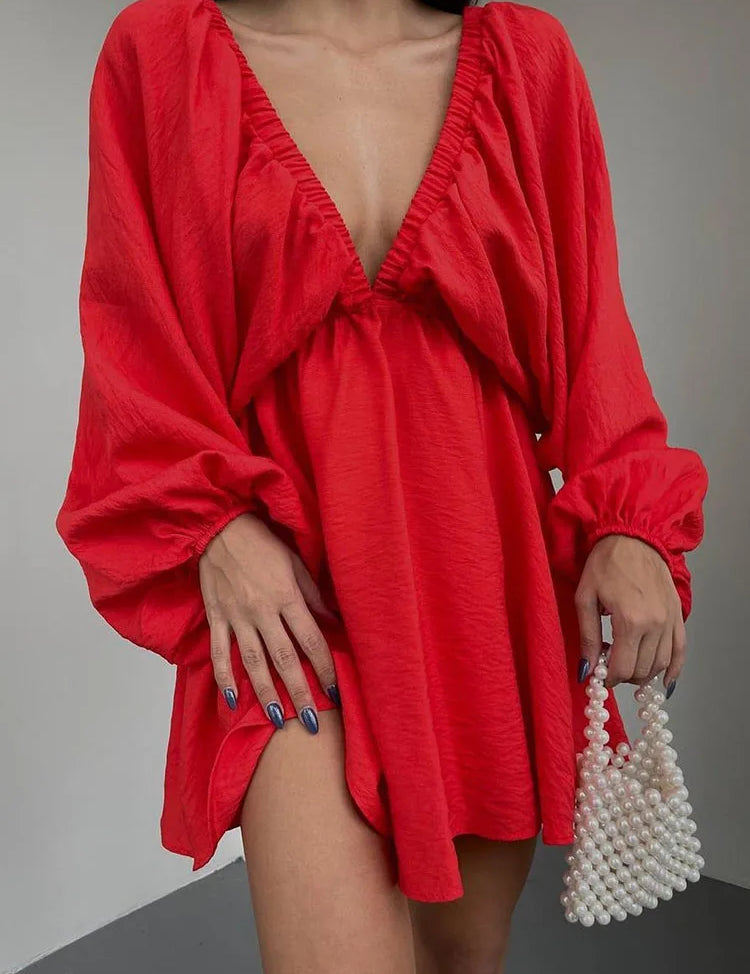 Donna con abito rosso a maniche lunghe e scollatura profonda, borsa di perle. Moda elegante, abbigliamento femminile trendy.