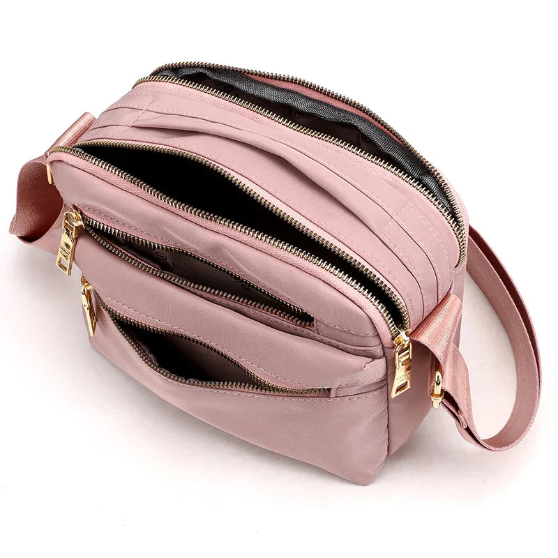 Borsa a tracolla rosa con cerniere dorate, design multi-scomparto, ideale per moda femminile, accessorio elegante e pratico per ogni occasione.