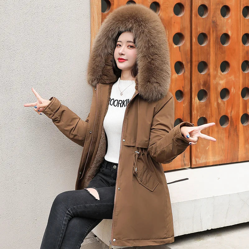 Giacca invernale marrone con cappuccio in pelliccia sintetica, indossata da una donna. Moda femminile, abbigliamento caldo, stile casual.