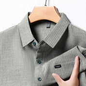 Camicia uomo grigia a righe, colletto classico, bottoni blu, tessuto leggero, elegante e casual, ideale per ufficio o eventi formali.