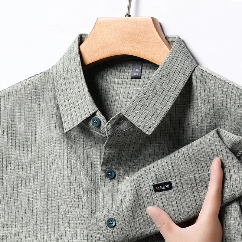 Camicia uomo grigia a righe, colletto classico, bottoni blu, tessuto leggero, elegante e casual, ideale per ufficio o eventi formali.