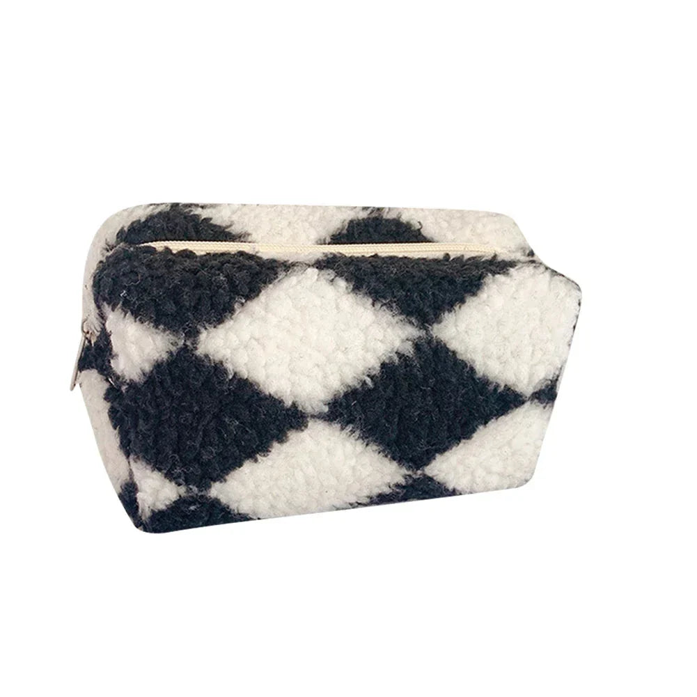Astuccio trucco in tessuto morbido a quadri bianchi e neri, chiusura con zip. Design elegante e pratico per cosmetici e accessori.