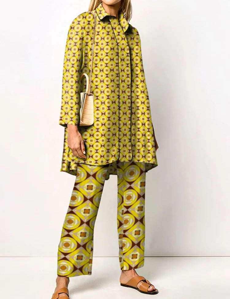 Abito donna fantasia geometrica giallo-verde, tunica e pantaloni coordinati, borsa beige, sandali marroni. Moda femminile elegante e colorata.