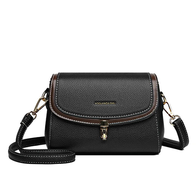 Borsa a tracolla in pelle nera con dettagli marroni, chiusura a fibbia dorata e tracolla regolabile. Elegante accessorio moda donna.