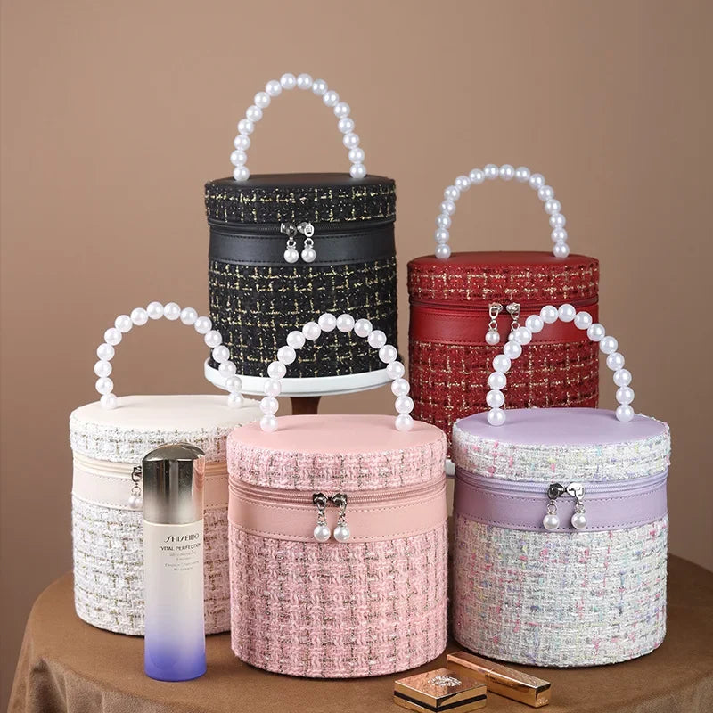 Cinque borse rotonde in tessuto tweed con manico di perle, colori assortiti, su sfondo marrone. Accessori moda eleganti e chic.