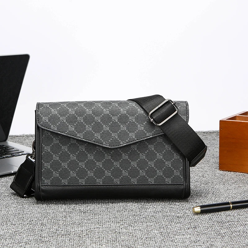 Borsa a tracolla uomo in pelle nera e tessuto grigio con motivo geometrico, elegante e moderna, ideale per lavoro e viaggio. Accessorio moda maschile.