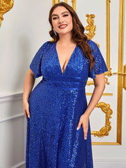 Abito lungo blu con paillettes, scollo a V profondo, maniche corte, indossato da una donna sorridente in un ambiente elegante con dettagli dorati.