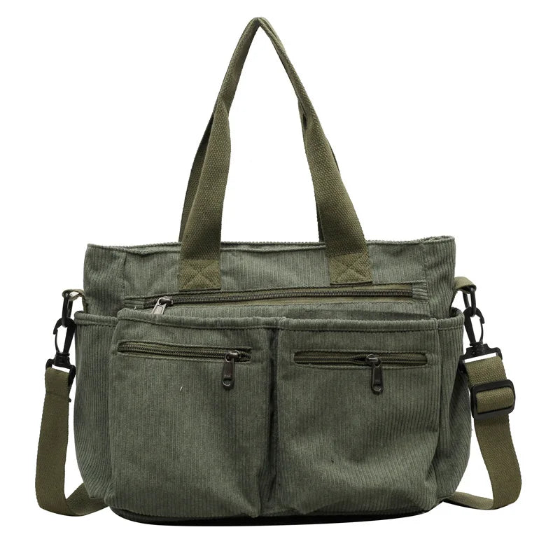 Borsa a tracolla verde in tessuto a coste, con manici e tasche multiple con cerniera. Design casual, ideale per uso quotidiano e viaggi.