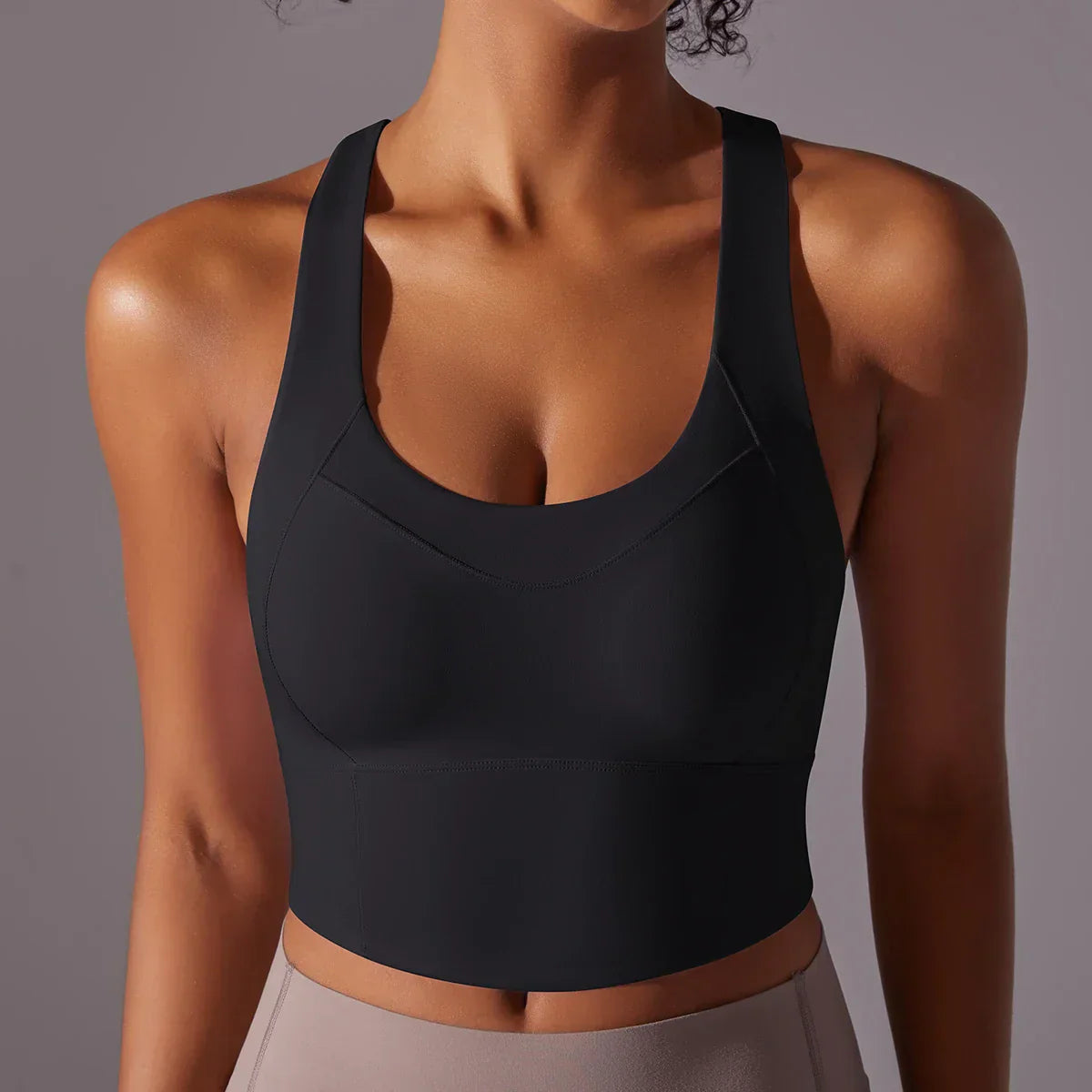 Top sportivo nero da donna, design senza maniche, tessuto elasticizzato, ideale per yoga e fitness. Comfort e stile per allenamenti intensi.