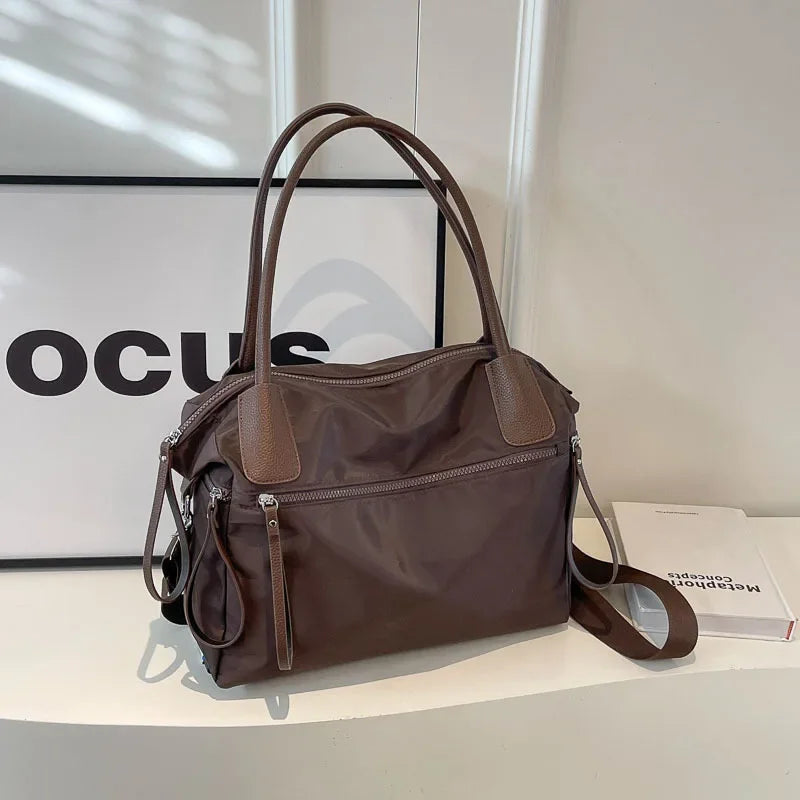 Borsa a tracolla marrone in pelle sintetica, design elegante con doppia maniglia e tasche con zip, ideale per moda donna e uso quotidiano.