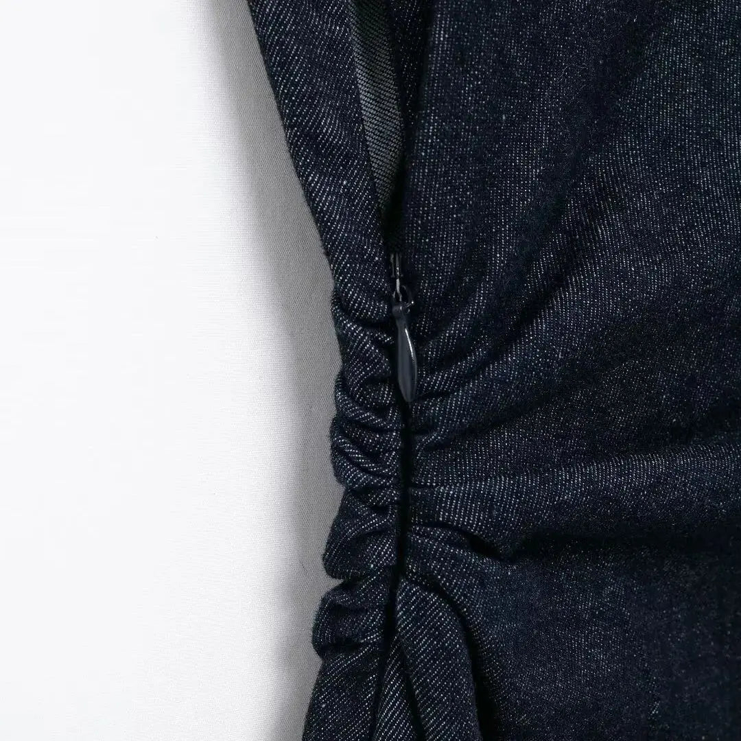 Vestito nero in denim con arricciature laterali, chiusura a zip nascosta. Elegante e moderno, perfetto per occasioni casual e serali.