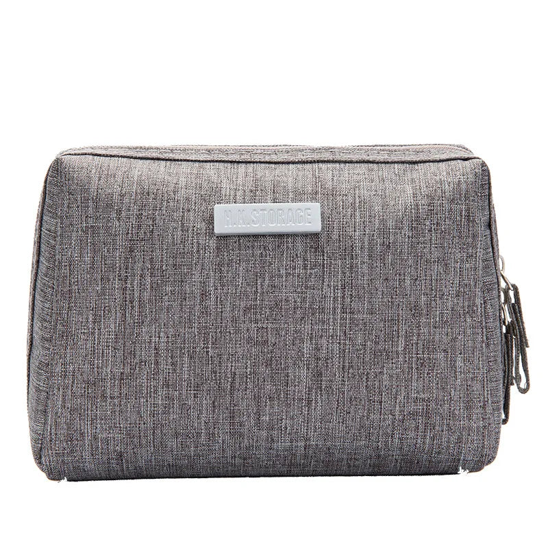 Astuccio grigio in tessuto con cerniera, design rettangolare, ideale per scuola o ufficio. Accessorio pratico e resistente per organizzare penne e matite.