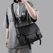 Borsa a tracolla nera unisex, design moderno, indossata su maglietta grigia con logo. Accessorio moda casual, ideale per uso quotidiano.