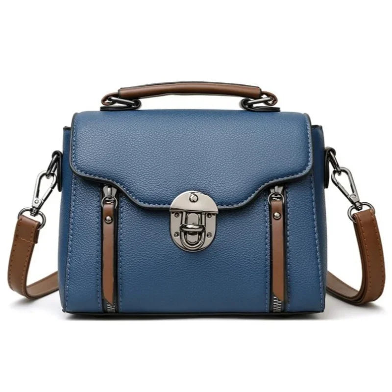 Borsa a tracolla in pelle blu con manico marrone, chiusura a scatto in metallo, dettagli eleganti, ideale per moda donna, accessorio versatile.