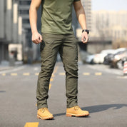 Uomo in pantaloni cargo verdi e stivali gialli su strada urbana. Moda casual maschile, abbigliamento outdoor, stile militare.