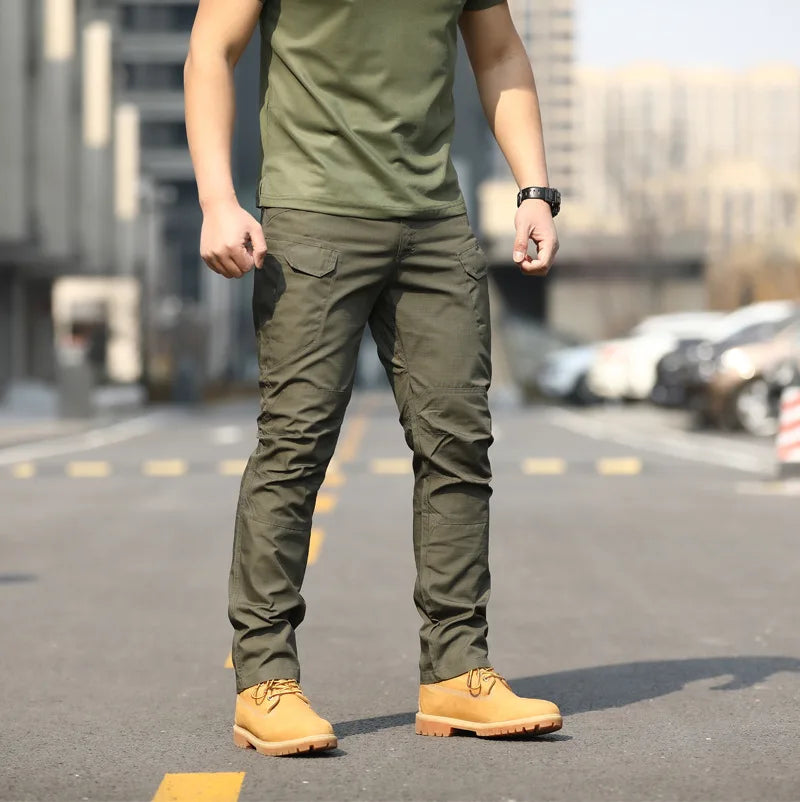 Uomo in pantaloni cargo verdi e stivali gialli su strada urbana. Moda casual maschile, abbigliamento outdoor, stile militare.