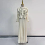 Abito lungo bianco elegante con giacca ricamata, maniche lunghe, colletto con fiocco, gonna plissettata. Perfetto per cerimonie e occasioni speciali.