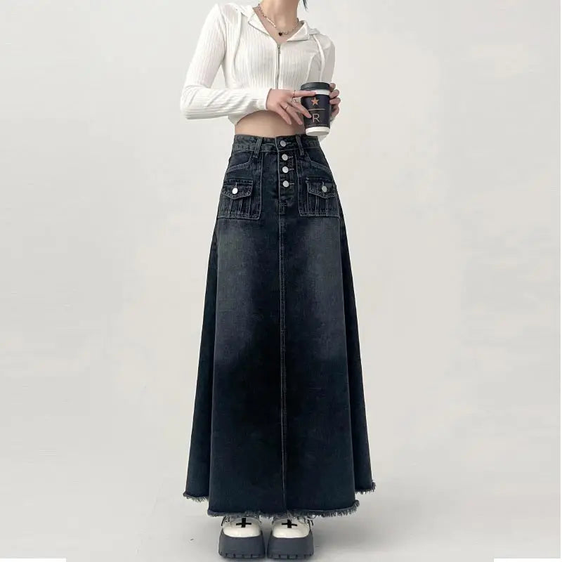 Gonna lunga in denim nero con bottoni, tasche frontali, abbinata a top bianco a coste. Look casual chic, moda donna autunno.
