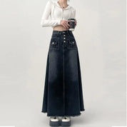 Gonna lunga in denim nero con bottoni, tasche frontali, abbinata a top bianco a coste. Look casual chic, moda donna autunno.