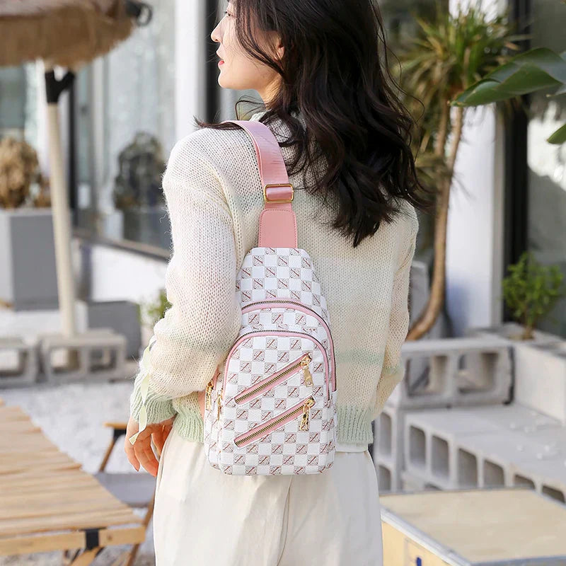 Donna con zaino a tracolla bianco e rosa, motivo a scacchi, all'aperto. Moda femminile, accessori eleganti, stile casual.