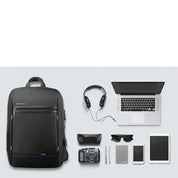Zaino nero per laptop con accessori tecnologici: cuffie, fotocamera, laptop, smartphone, tablet, occhiali da sole. Ideale per viaggi e lavoro.