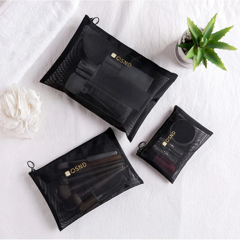 Tre astucci neri in rete per cosmetici su sfondo bianco, contenenti pennelli e trucchi. Design elegante, ideale per organizzare il make-up.