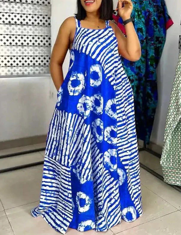 Abito lungo estivo blu con motivo tie-dye bianco, senza maniche, tasche laterali, indossato da donna in negozio di moda.