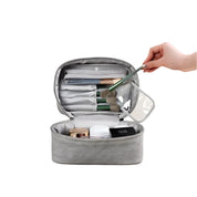 Astuccio da trucco grigio aperto con pennelli, cosmetici e scomparti organizzati. Ideale per viaggi, accessori make-up, beauty case compatto.