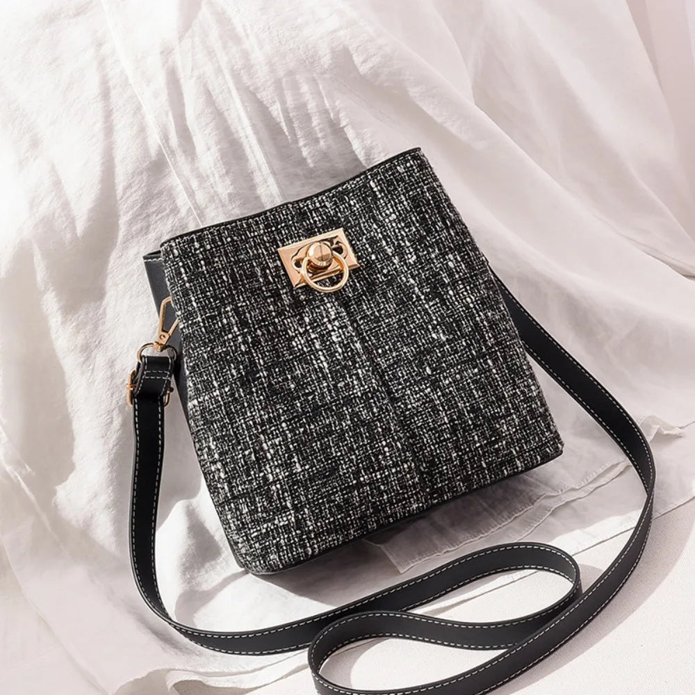 Borsa a tracolla in tweed nero e bianco con chiusura dorata, design elegante e moderno, perfetta per moda femminile e accessori di lusso.