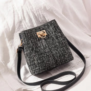 Borsa a tracolla in tweed nero e bianco con chiusura dorata, design elegante e moderno, perfetta per moda femminile e accessori di lusso.