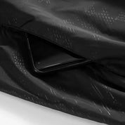 Smartphone nero in tasca di giacca impermeabile nera, design elegante e moderno, accessorio tecnologico, moda outdoor, protezione dispositivo.