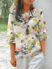 Donna con maglia floreale a maniche corte, colori pastello, indossa cappello di paglia e collana nera. Moda estiva casual, stile boho chic.