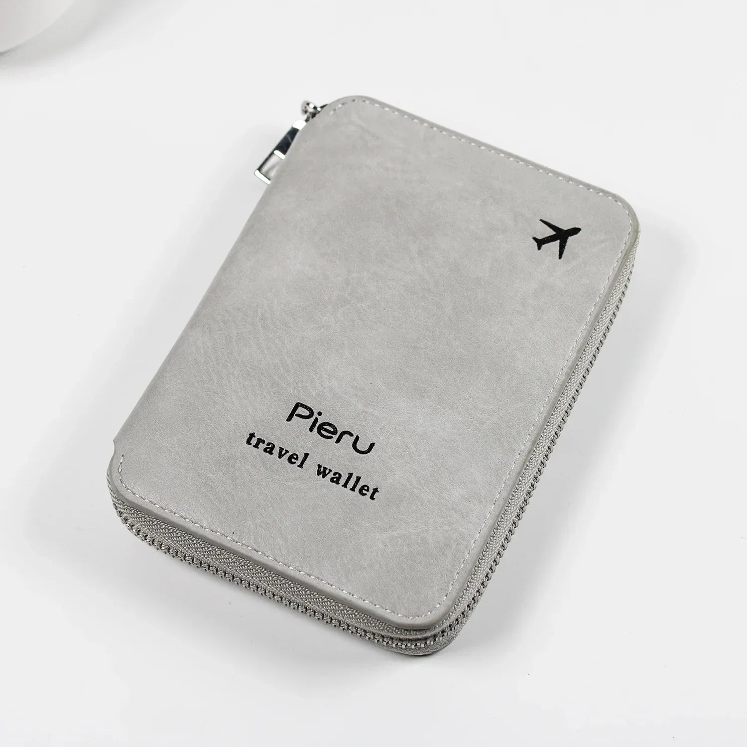 Portafoglio da viaggio grigio in pelle sintetica con cerniera, logo "Pieru" e icona aereo, ideale per documenti e carte.