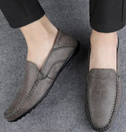 Scarpe mocassini da uomo in pelle grigia, design elegante e cuciture dettagliate, ideali per look casual e formali. Comfort e stile garantiti.