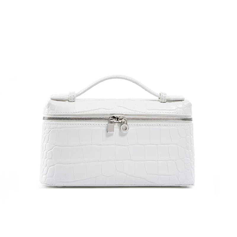 Borsa cosmetica bianca in pelle effetto coccodrillo con manico superiore e chiusura a zip. Elegante e pratica per viaggi e organizzazione.