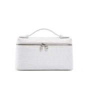 Borsa cosmetica bianca in pelle effetto coccodrillo con manico superiore e chiusura a zip. Elegante e pratica per viaggi e organizzazione.