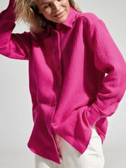 Camicia donna fucsia a maniche lunghe, tessuto leggero, abbinata a pantaloni bianchi. Moda casual, stile primaverile, abbigliamento femminile.