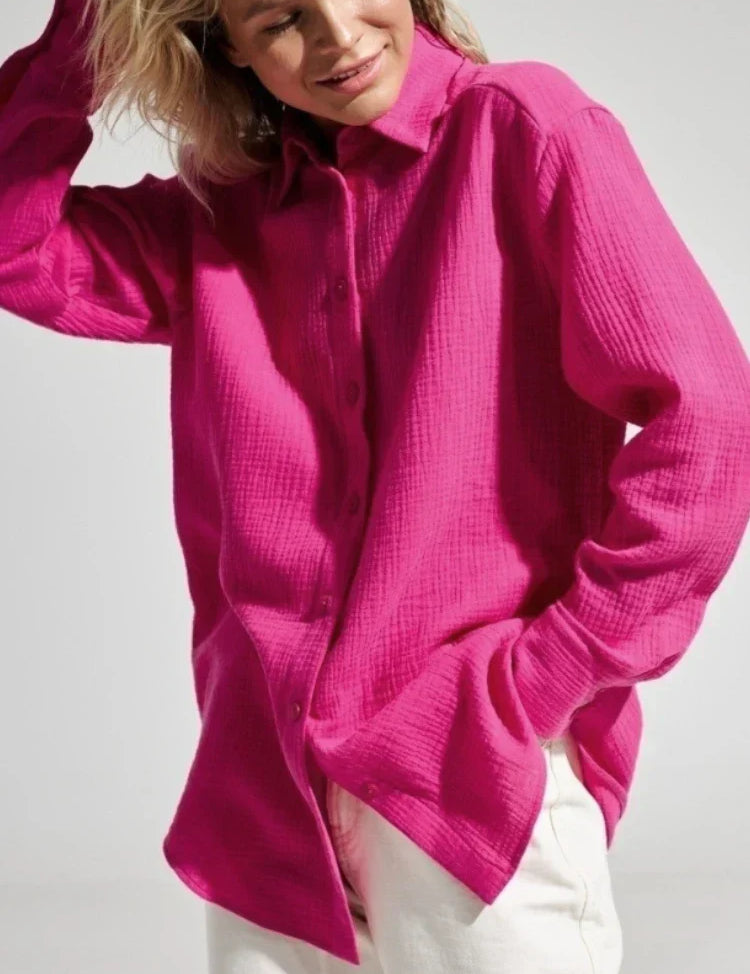 Camicia donna fucsia a maniche lunghe, tessuto leggero, abbinata a pantaloni bianchi. Moda casual, stile primaverile, abbigliamento femminile.