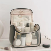 Borsa da toilette trasparente con zip, contenente flaconi di cosmetici e accessori da viaggio. Ideale per organizzare prodotti di bellezza.