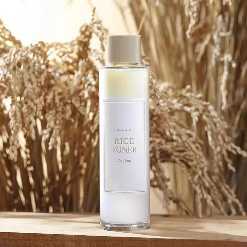 Bottiglia di tonico al riso coreano su sfondo di spighe, skincare naturale, idratante viso, prodotto di bellezza, cosmetico K-beauty.