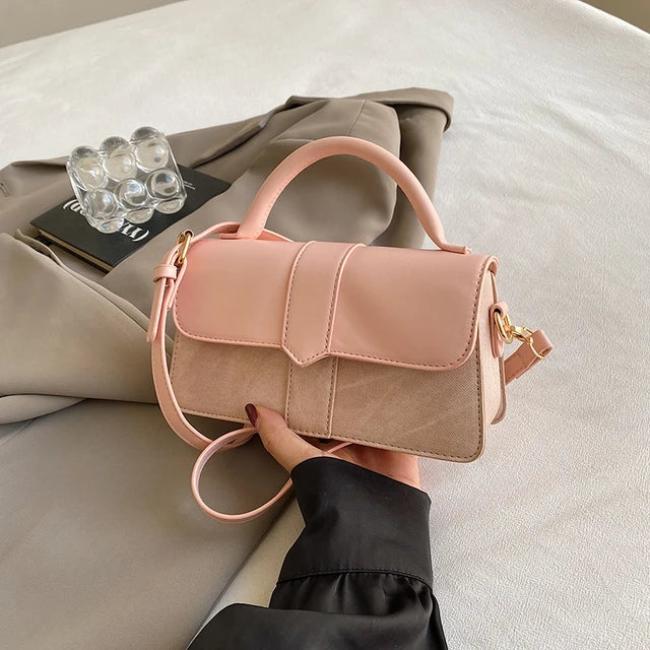 Borsa a tracolla rosa in pelle e tessuto su giacca beige, design elegante, manico superiore, chiusura a patta, moda donna, accessorio chic.